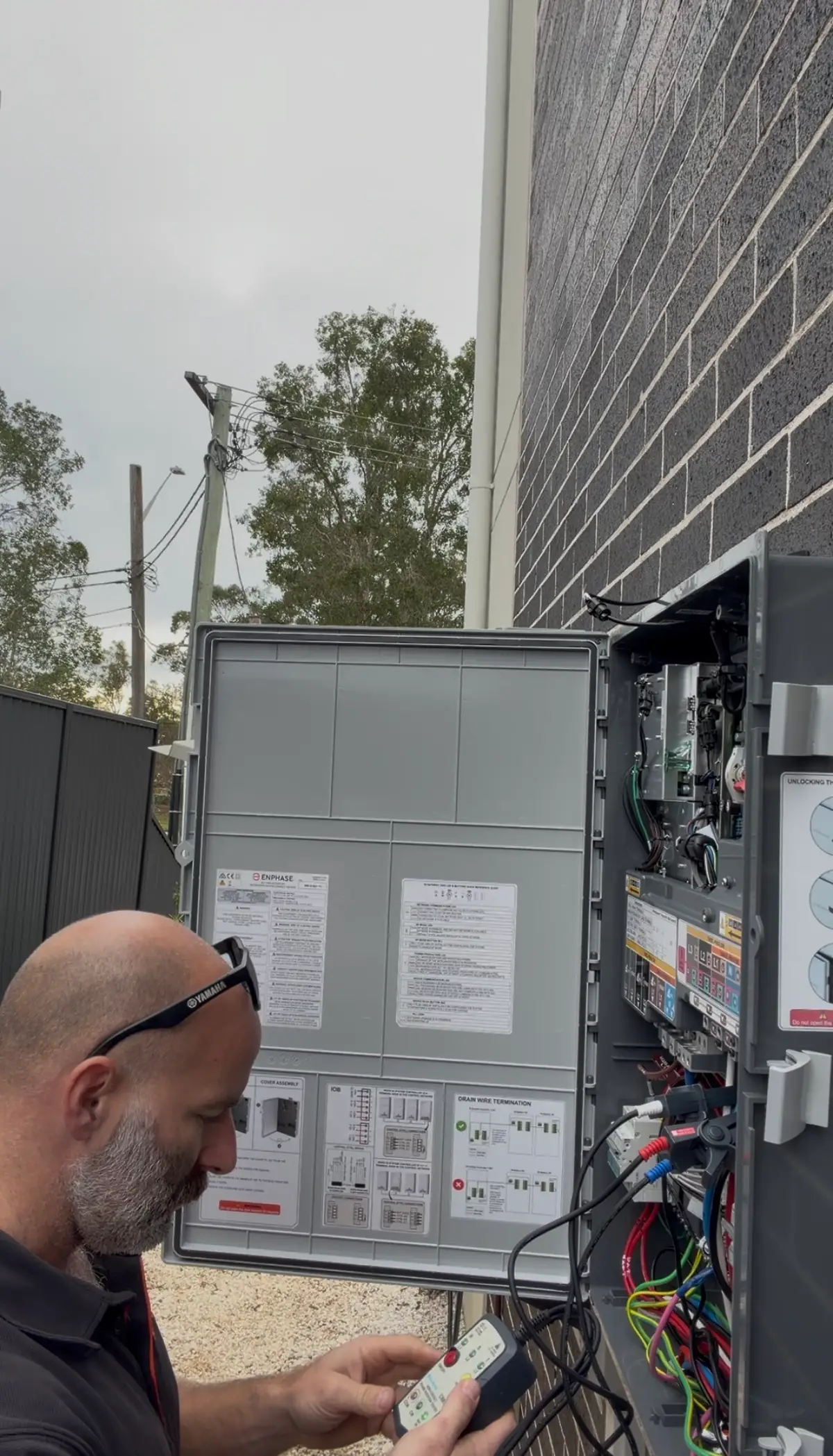 Licensed electrician inspecting a switchboard during on-site electrical work in Sydney